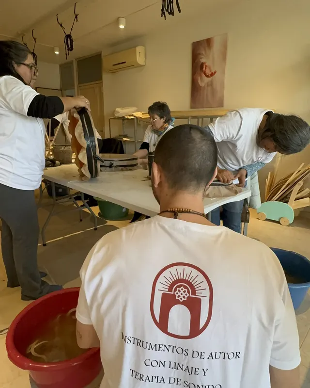 Ra de espaldas con la remera del taller, mirando cómo trabajan los alumnos